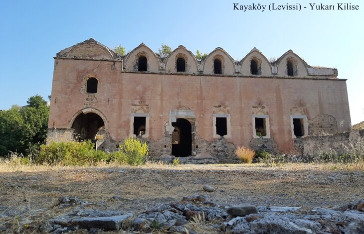 Kayaköy (Levissi)’de yer alan tarihi Yukarı Kilise’nin ön cephesi ve taş zeminli açık alan.