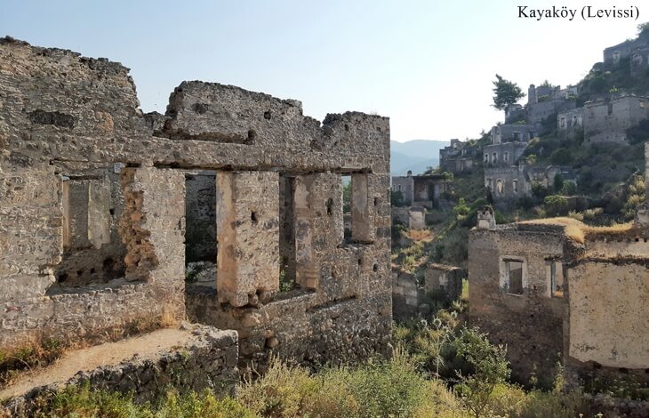 Kayaköy (Levissi) mübadele sonrası terk edilmiş taş evler ve arka planda dağlık manzara.