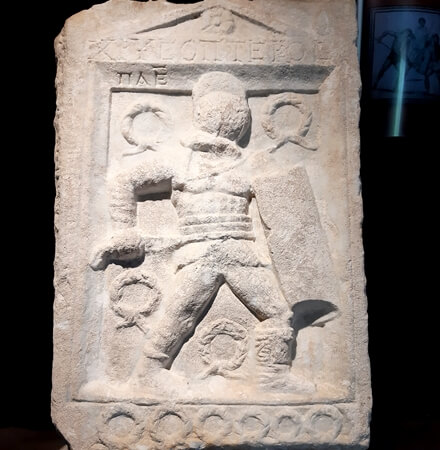Antik Roma dönemine ait gladyatör kabartması – kalkan ve kılıç taşıyan savaşçı figürü, müze sergisi