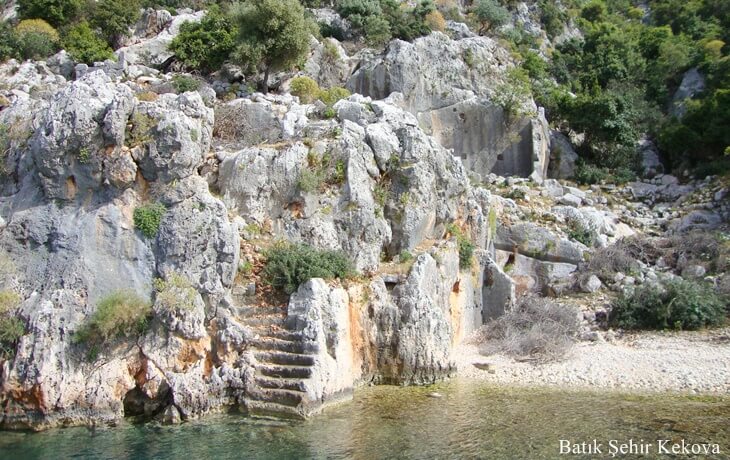 Batık Şehir Kekova’da deniz kıyısında kayalara oyulmuş antik basamaklar ve kıyıya uzanan tarihi kalıntılar