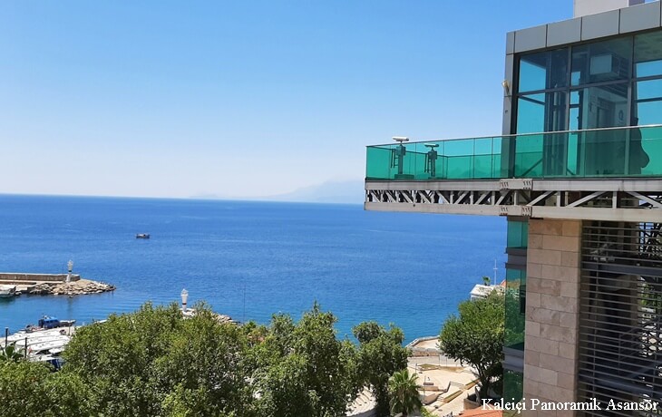 Antalya Kalei&ccedil;i Panoramik Asans&ouml;r &ndash; Yat Limanı manzaralı modern cam asans&ouml;r ve Akdeniz deniz manzarası.