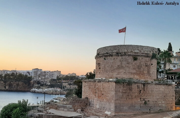 Antalya Kalei&ccedil;i Hıdırlık Kulesi &ndash; Roma d&ouml;nemine ait kare kaide &uuml;zerine yuvarlak kule, Akdeniz manzarası ve g&uuml;n batımı.