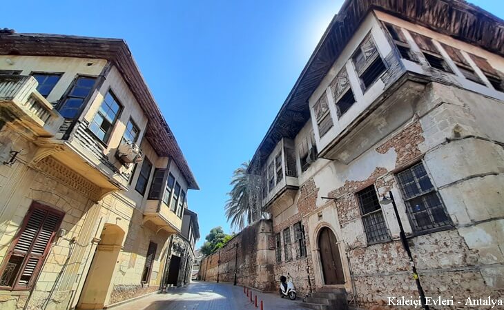 Antalya Kalei&ccedil;i&rsquo;nde taş duvarlı ve cumbalı tarihi Osmanlı evleri &ndash; dar sokaklar ve mavi g&ouml;ky&uuml;z&uuml; altında nostaljik atmosfer.
