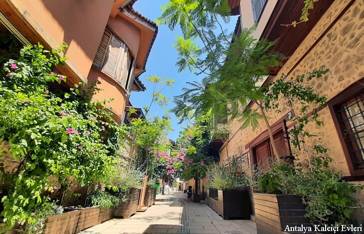 Antalya Kalei&ccedil;i&rsquo;nde begonvillerle s&uuml;sl&uuml; dar taş sokaklar ve restore edilmiş tarihi evler.