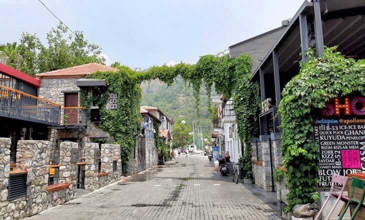 Marmaris Barlar Sokağı&rsquo;nda taş binalar, sarmaşıklarla kaplı kemer ve y&uuml;r&uuml;y&uuml;ş yolu