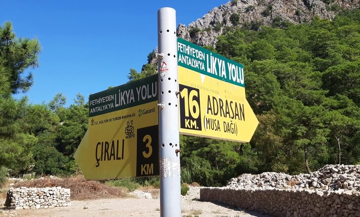 Likya Yolu üzerinde Çıralı ve Adrasan yönlerini gösteren sarı yürüyüş tabelası