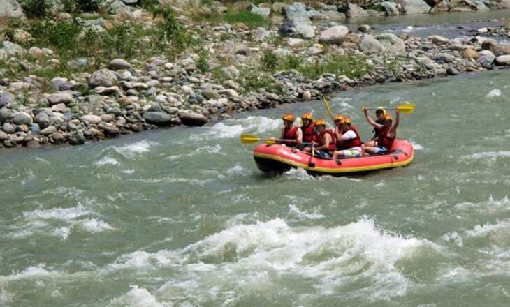 Dalgalı akıntıda ilerleyen rafting botu ve ekiplerin kürek çektiği heyecanlı an