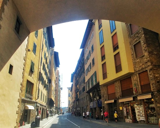 Floransa&rsquo;da Ponte Vecchio&rsquo;nun i&ccedil; ge&ccedil;idinden g&ouml;r&uuml;nen dar sokak, iki yanda sıralanan d&uuml;kk&acirc;nlar ve k&ouml;pr&uuml;n&uuml;n kemerli yapısı arasında uzanan tarihi &ccedil;arşılı k&ouml;pr&uuml; atmosferi