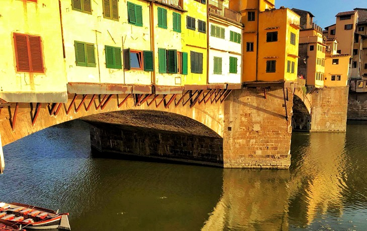 Floransa&rsquo;da Arno Nehri &uuml;zerinde yer alan Ponte Vecchio, k&ouml;pr&uuml; kemerleri altından yansıyan su, sarı tonlu yapılar ve k&ouml;pr&uuml;ye bitişik d&uuml;kk&acirc;nlarıyla tarihi bir &ccedil;arşılı k&ouml;pr&uuml; detayı