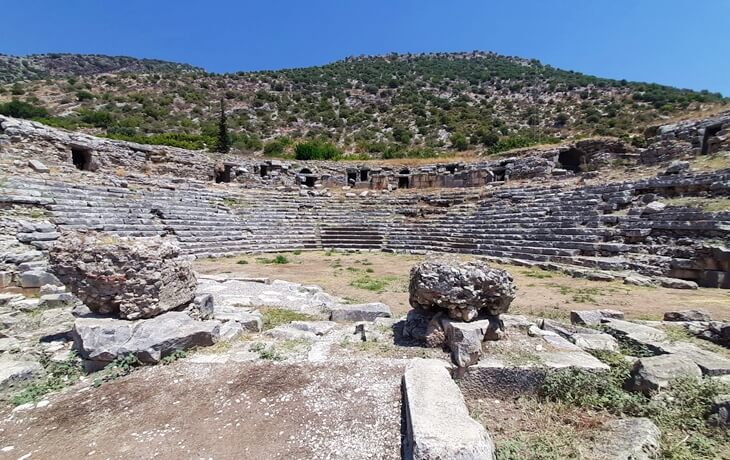 Limyra Antik Kenti – antik tiyatro kalıntıları ve sahne binasıyla birlikte dağ manzarası