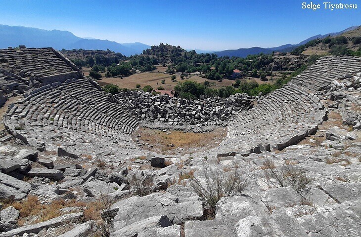 Selge Antik Kenti Tiyatrosu – Toros Dağları manzaralı taş basamaklı antik tiyatro kalıntısı
