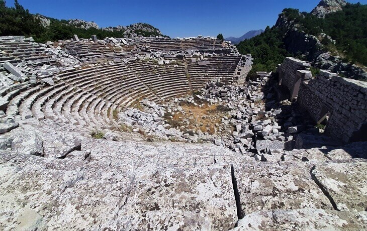 Termessos Antik Kenti – Dağ yamacına oyulmuş antik tiyatro kalıntıları ve çevresindeki Toros Dağları manzarası