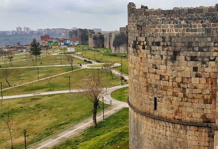 Diyarbakır surlarının taş kaplamalı burçları ve çevresindeki yeşil alanlar.