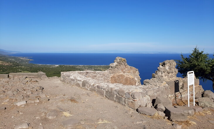 Assos akropol&uuml;nde taş temeller ve karşıda Midilli&rsquo;ye uzanan Ege panoraması