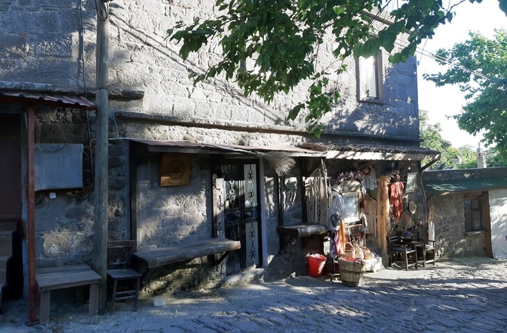 Behramkale&rsquo;de g&ouml;lgeli bir cephede taş konak ve otantik d&uuml;kkan
