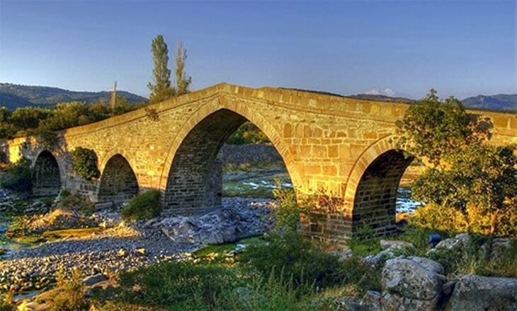 Tuzla &Ccedil;ayı &uuml;zerindeki H&uuml;davendigar K&ouml;pr&uuml;s&uuml;, g&uuml;n batımında taş kemerleriyle