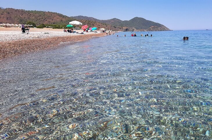 Antalya Kemer&rsquo;de yer alan &Ccedil;ıralı Plajı&rsquo;nda berrak deniz suyu, &ccedil;akıllı sahil ve y&uuml;zen insanlar