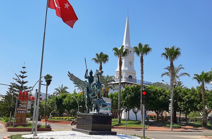 Antalya Kemer merkezinde, saat kulesi &ouml;n&uuml;nde yer alan Pegasus heykeli ve T&uuml;rk bayrağı
