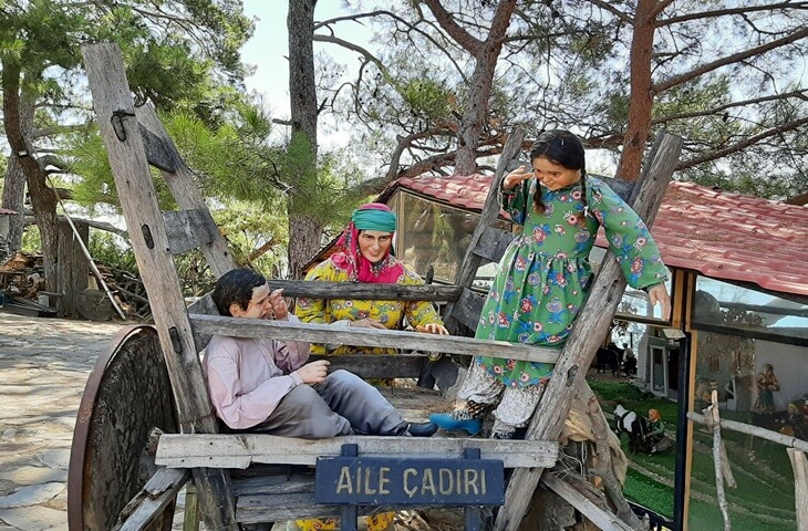 Kemer Y&ouml;r&uuml;k Parkı&rsquo;nda geleneksel kıyafetli Y&ouml;r&uuml;k heykelleri ve &ldquo;Aile &Ccedil;adırı&rdquo; tabelası bulunan otantik k&ouml;şe