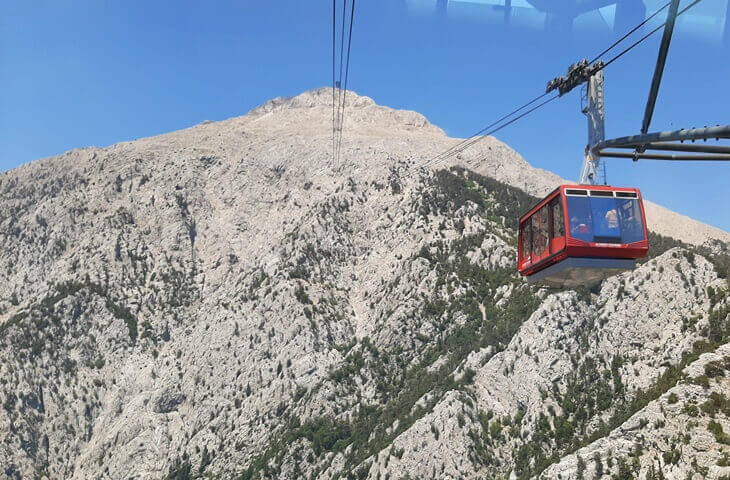 Olympos Teleferik kabini, sarp kayalıklarla kaplı Tahtalı Dağı zirvesine doğru ilerliyor