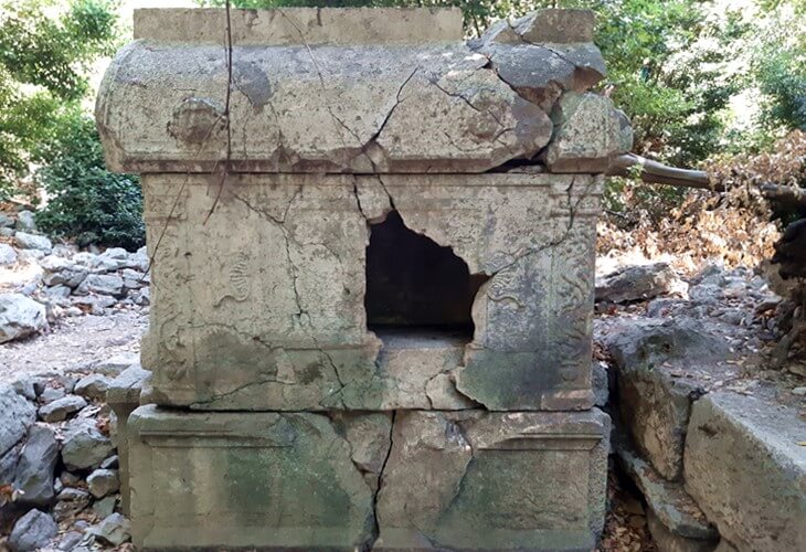 Olympos Antik Kenti’nde yer alan, ön yüzü kırılmış, üzerinde süslemeler bulunan Antimachos’a ait taş lahit