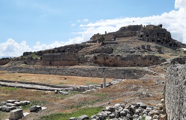 Tlos Antik Kenti'nde tiyatro kalıntıları, yamaca kurulu kaya mezarları ve üst kısımda yer alan Orta Çağ kalesi