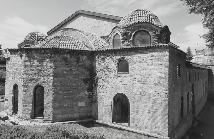İznik Ayasofya Orhan Camii’nin siyah-beyaz dış cephe görüntüsü; Bizans dönemine özgü kubbeler ve taş-tuğla duvar detayları.