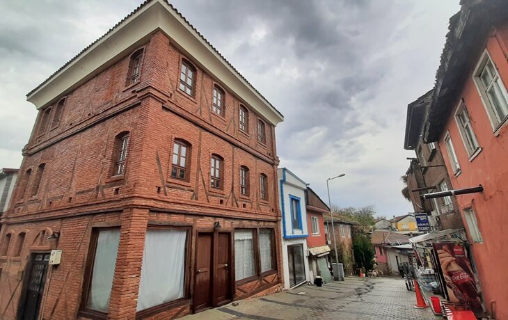 G&ouml;lyazı&rsquo;nın merkezinde yer alan restore edilmiş &uuml;&ccedil; katlı kırmızı tuğla ev ve taş d&ouml;şeli sokak