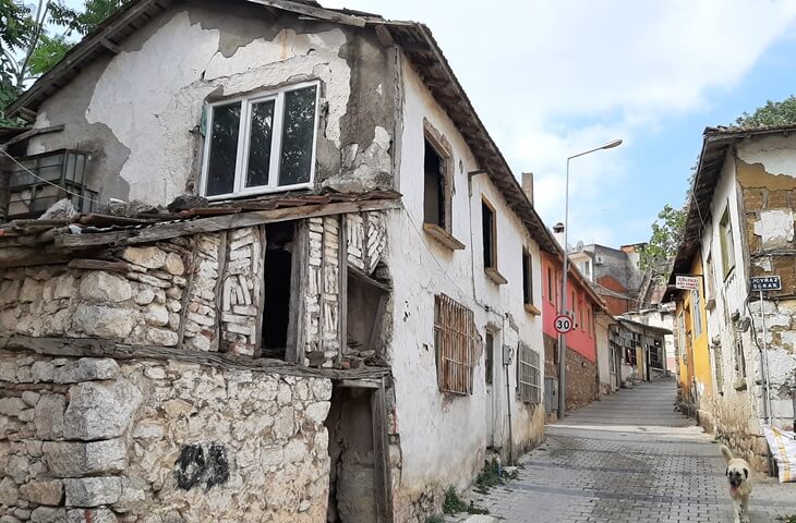 G&ouml;lyazı K&ouml;y&uuml;&rsquo;nde zamanla yıpranmış taş ve kerpi&ccedil;ten yapılmış geleneksel bir eski ev ve dar sokak